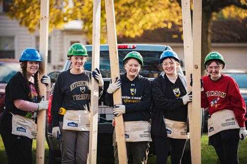 A group of honors students doing volunteer work for habitat for humanity